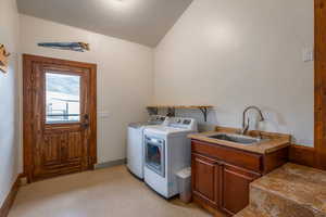 Laundry room featuring washer and dryer, cabinet space, and light flooring