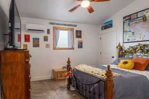Bedroom featuring dark colored carpet, vaulted ceiling, and a ceiling fan