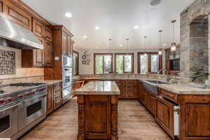 Kitchen featuring a peninsula, stainless steel appliances, light wood-type flooring, and a kitchen island