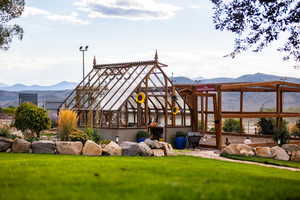 Back of property featuring an exterior structure, a mountain view, and an outdoor structure