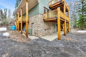 Exterior space featuring stone siding, an attached garage, and a deck