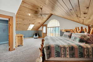 Bedroom featuring wooden ceiling, carpet, a ceiling fan, and wallpapered walls