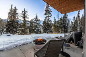 Snow covered patio with a fire pit and a patio