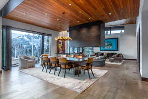 Dining room featuring a high wooden ceiling, light wood-type flooring, and suspended lighting