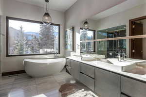 Bathroom with a soaking tub, double vanity, and a mountain view