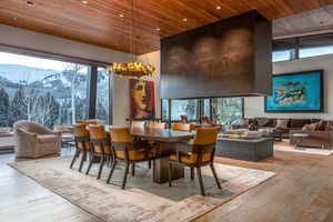 Dining space with a high wood ceiling, light wood finished floors, recessed lighting, and a mountain view