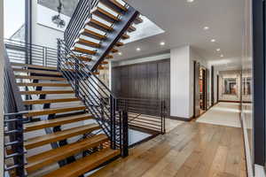 Stairway with wood-type flooring and recessed lighting