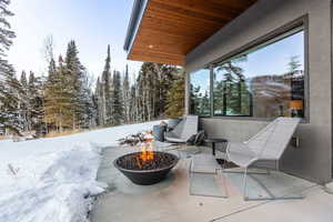 Snow covered patio featuring an outdoor fire pit and a patio
