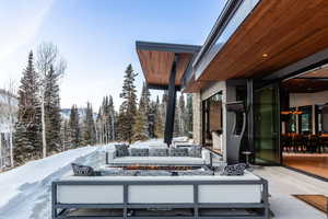 Snow covered patio with an outdoor living space with a fire pit and a patio area