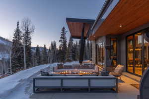 Snow covered patio with a fire pit and a patio area