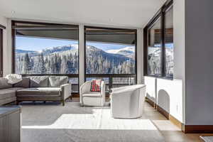Living area featuring a mountain view, light wood-style flooring, and a wooded view
