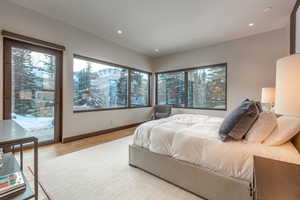 Bedroom with access to exterior, light wood-style flooring, and recessed lighting