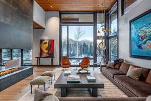 Living area with a mountain view, hardwood / wood-style flooring, expansive windows, a high wood ceiling, and recessed lighting