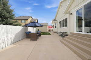 Fenced backyard featuring a patio, outdoor seating, and a residential view