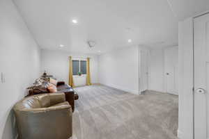 Sitting room with light colored carpet and recessed lighting