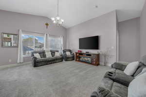 Carpeted living room featuring suspended lighting and a high ceiling