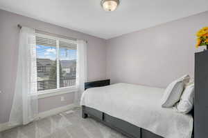 Bedroom featuring light carpet and baseboards