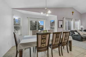 Dining space featuring vaulted ceiling, hanging lights, and light tile patterned floors