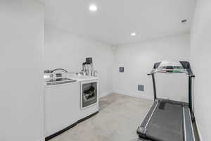 Laundry room with concrete floors, recessed lighting, and washing machine and dryer