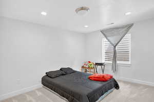 Carpeted bedroom with baseboards and recessed lighting