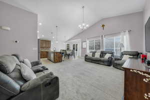 Living area featuring lofted ceiling, hanging lights, and light colored carpet