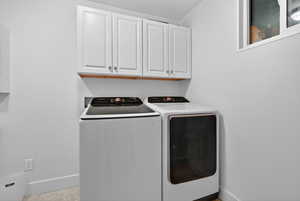 Laundry area featuring cabinet space and washing machine and clothes dryer