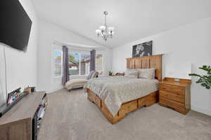 Bedroom featuring lofted ceiling, light carpet, and hanging lights