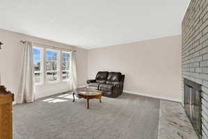 Living room featuring a brick fireplace and light carpet