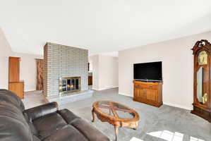 Living area with light carpet and a fireplace