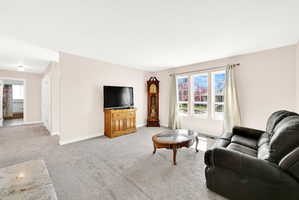 Living room featuring light carpet and baseboards