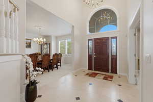 Foyer with hanging lights, a high ceiling, and light tile patterned floors