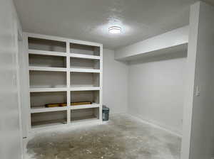 Large mostly finished space with laundry area, storage shelves and outdoor access