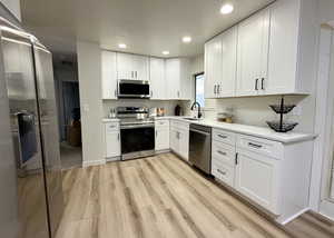 Light and bright kitchen with NEW cabinets, countertops, flooring, stainless steel appliances, and recessed lighting