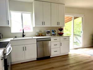 Light and bright kitchen with new windows and sliding glass door to large entertainer deck