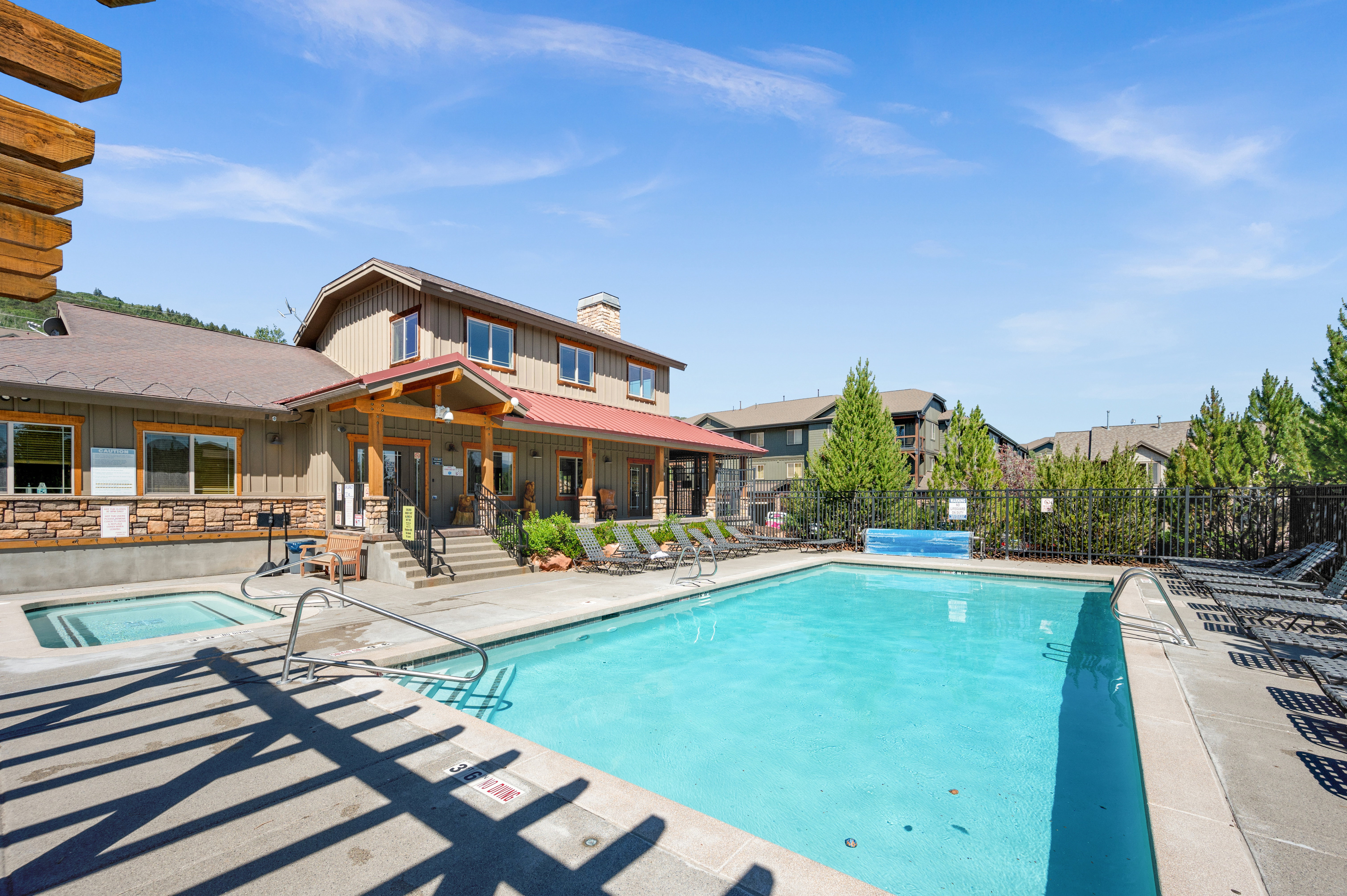 Outdoor swimming pool with concrete decking and adjacent hot tub