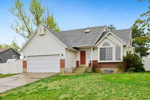 View of front of home with a gate, an attached garage, concrete driveway, brick siding, and a shingled roof