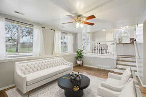 Sitting room with wood finished floors, ceiling fan, and a textured ceiling