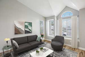 Living room featuring light wood-style flooring and vaulted ceiling