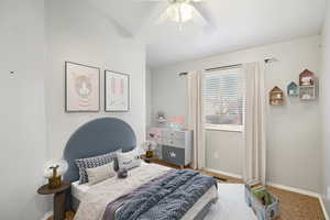 Carpeted bedroom featuring baseboards and a ceiling fan