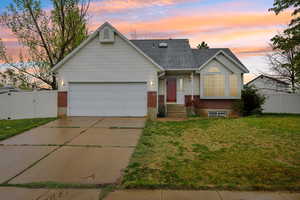 View of front of property featuring brick siding, a gate, driveway, a garage, and a shingled roof