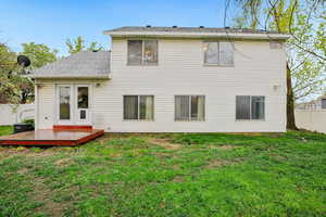 Rear view of property featuring a shingled roof and a wooden deck