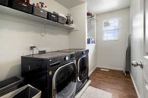 Laundry room featuring separate washer and dryer and dark wood-type flooring