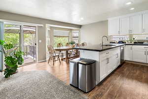Kitchen with a peninsula, white cabinetry, dark wood-style floors, a textured ceiling, and recessed lighting