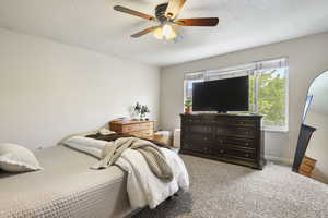 Bedroom with a textured ceiling, light carpet, and ceiling fan
