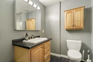 Bathroom with vanity and dark tile patterned flooring