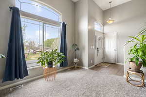 Foyer with light carpet and a high ceiling