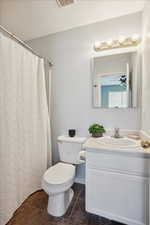 Full bath with vanity, a shower with shower curtain, a ceiling fan, and a textured ceiling