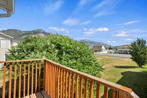 Wooden terrace with a mountain view, a yard, and a residential view