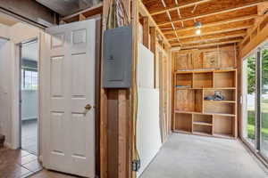 Misc room with electric panel and concrete flooring