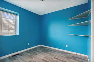Unfurnished room featuring light wood finished floors and baseboards